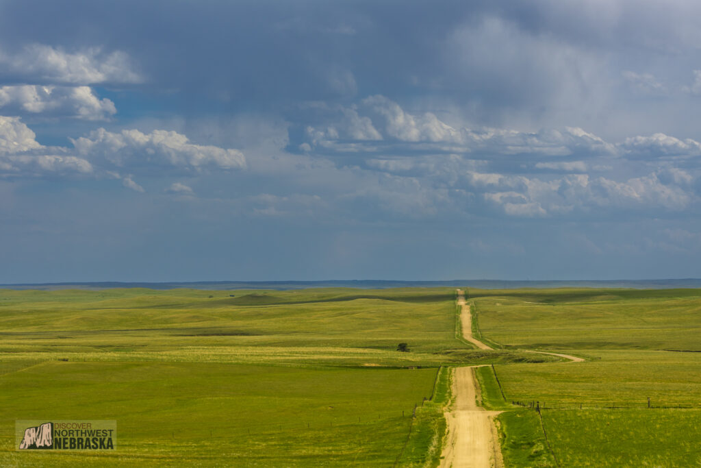 Winding country road with prairie grass and stormy skies