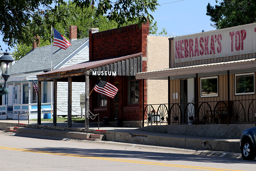 A row of museum buildings with an American flag and a banner that reads Nebraska's Top Town