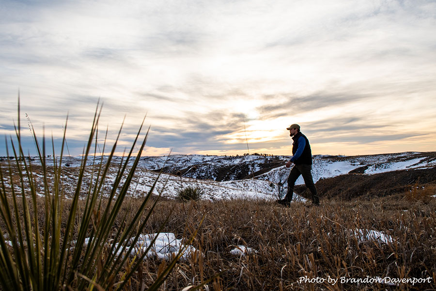A man walks across a snowy field
