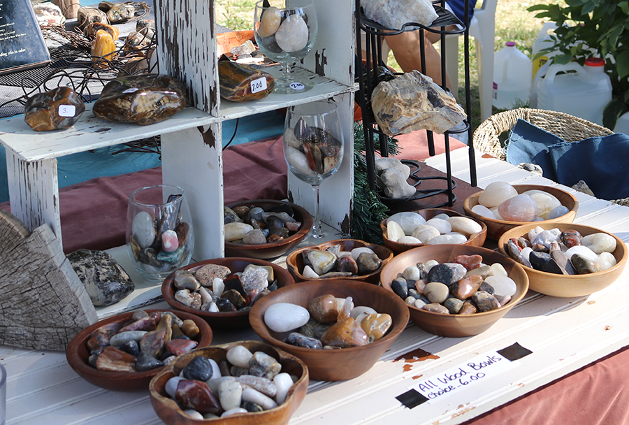 A collection of rocks displayed on white shelves and a table.
