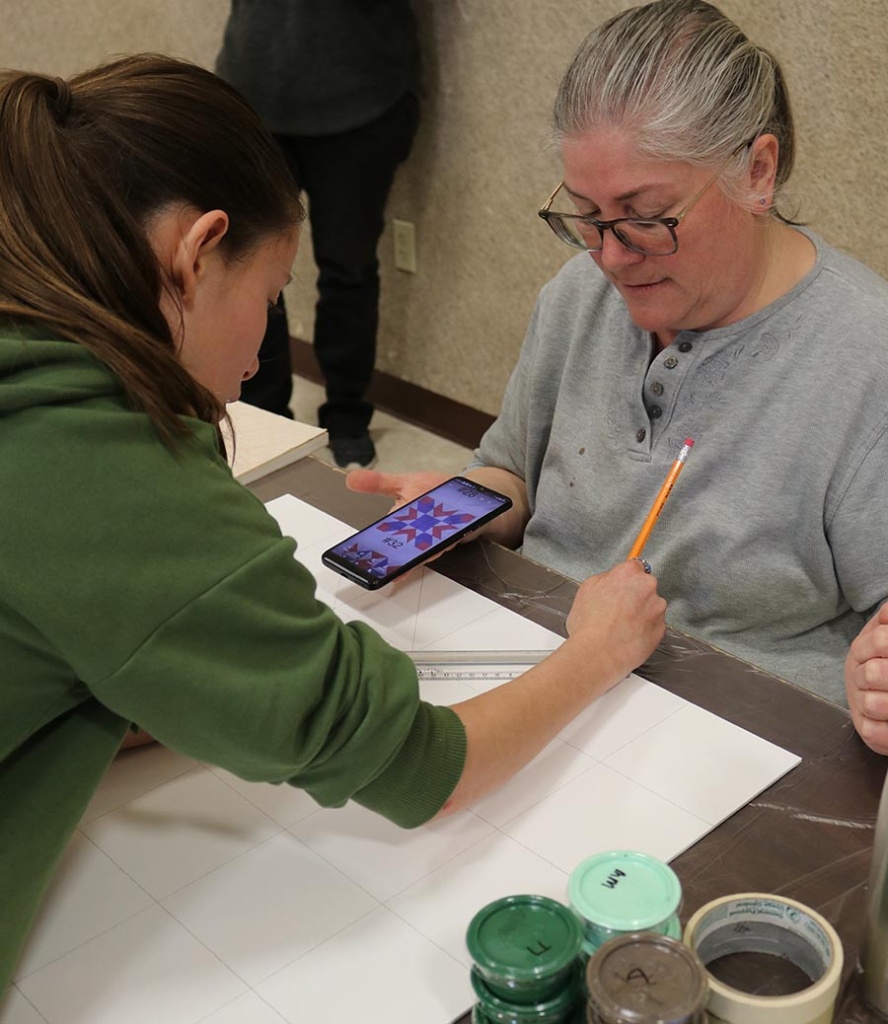 A family works on their design for a barn quilt