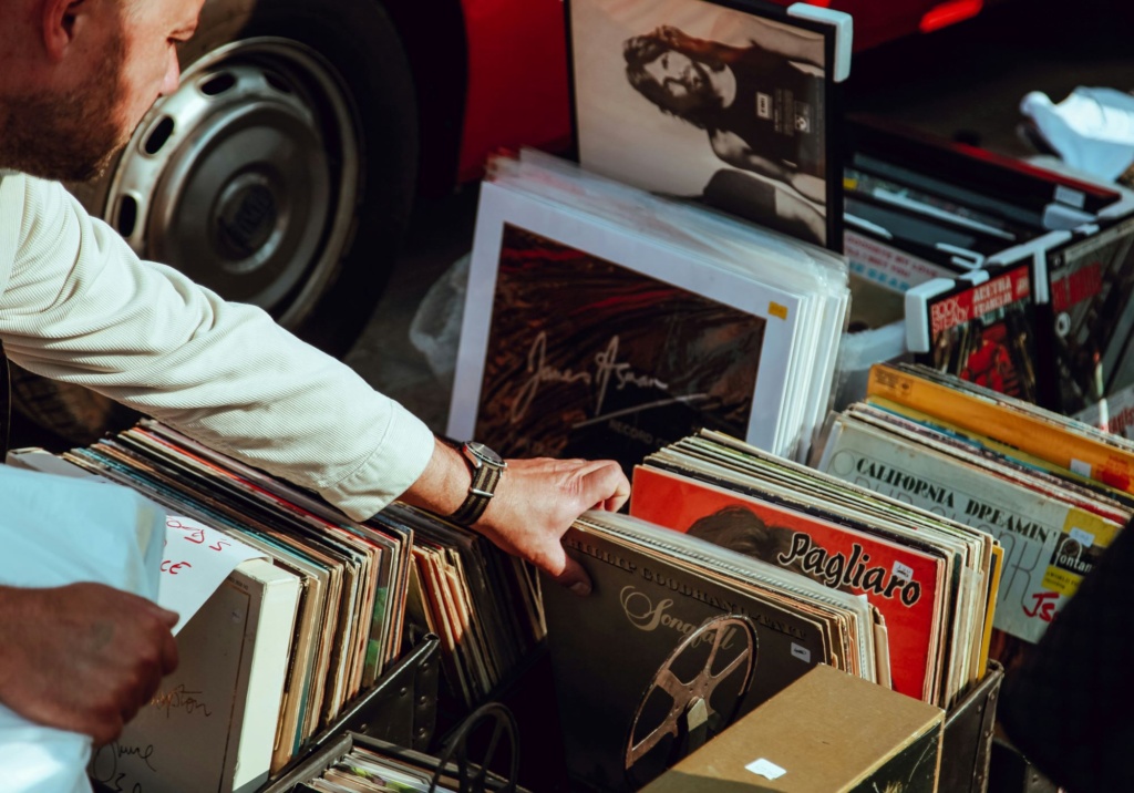 A person's hand reaches for a box of records.